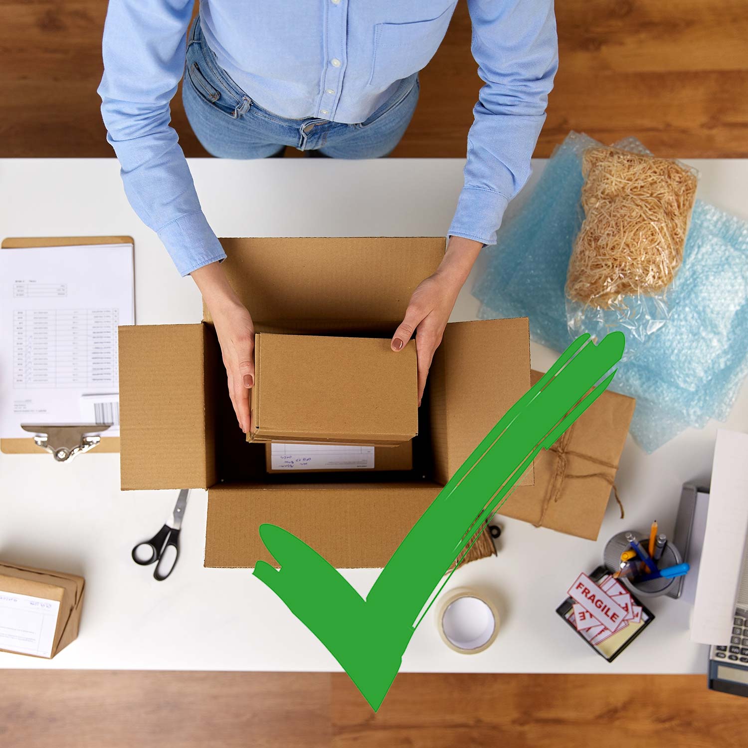 Person legt Innenverpackung in Außenverpackung eines Pakets und grüner Haken ist als OK-Symboil ist zu sehen